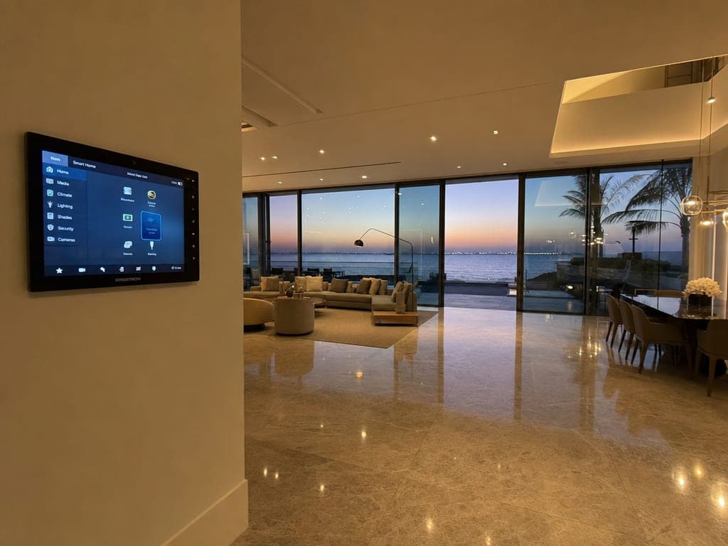 Saadiyat Island beachfront villa interior with custom Crestron touchscreen and warm scene lighting at dusk