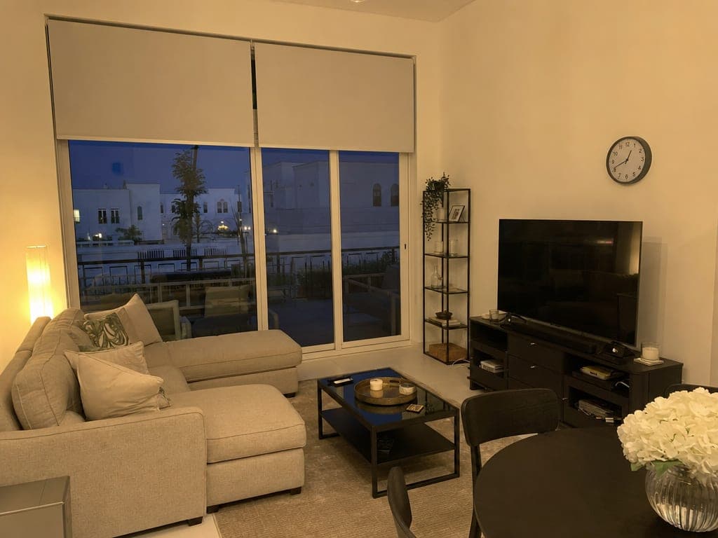Town Square townhouse living room at evening with IKEA smart blinds half-open and warm scene lighting active