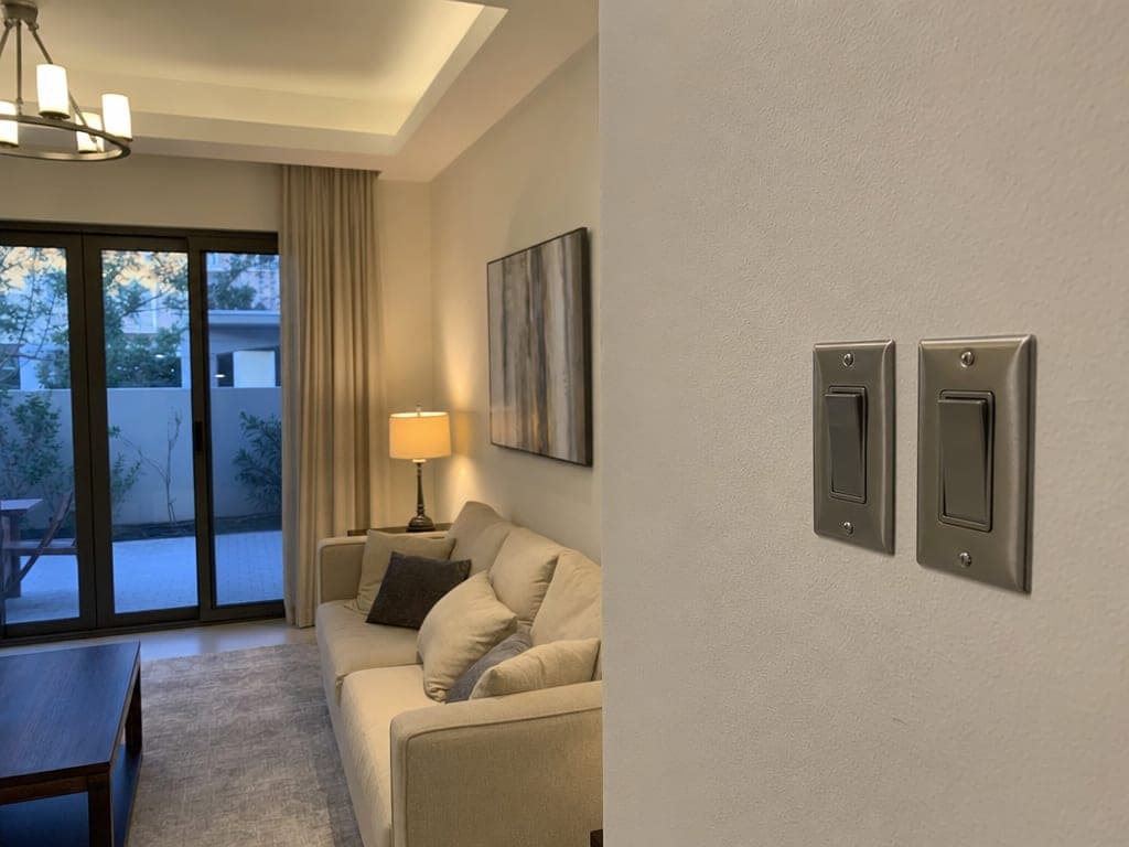 Mira townhouse living room with traditional brushed-nickel wall switches and warm scene lighting active at evening