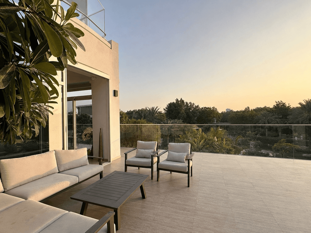 Al Barari villa terrace at golden hour with lush botanical garden, water feature and warm landscape lighting