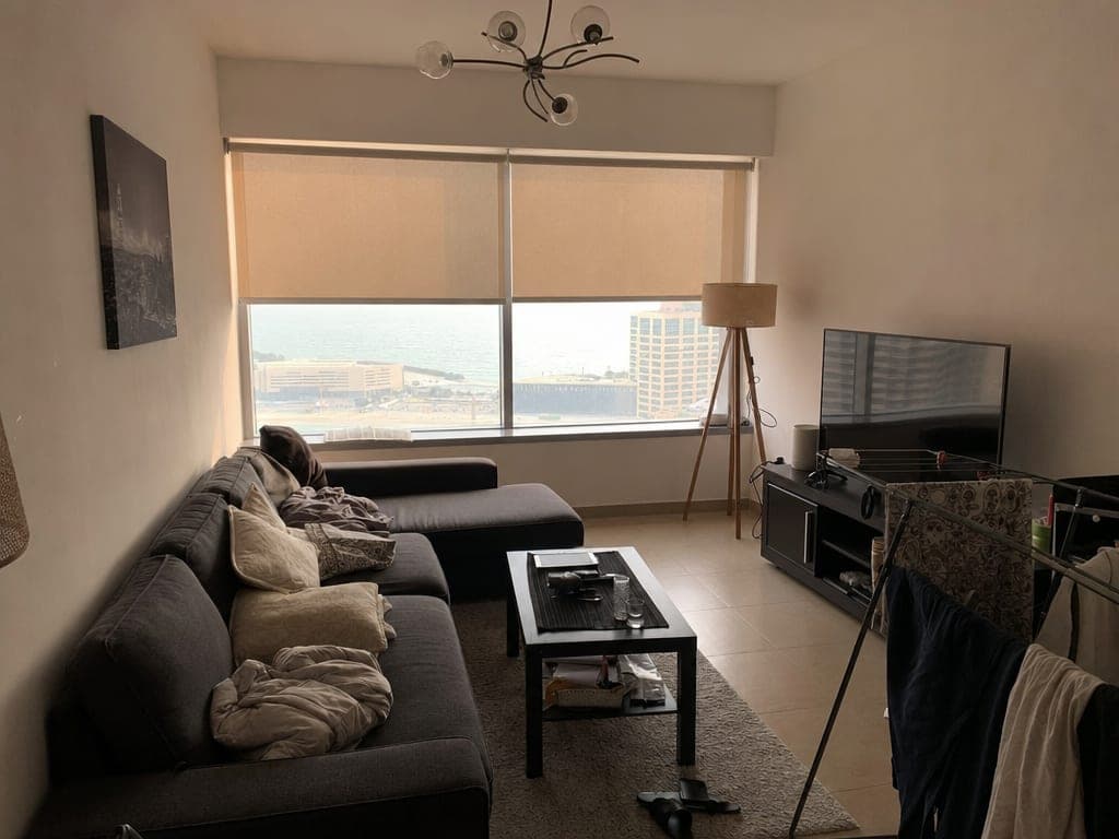 JBR Bahar 4 apartment living room at afternoon with motorized blinds half-closed and beach view filtered behind
