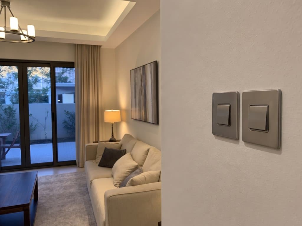 Mira townhouse living room with traditional brushed-nickel wall switches and warm scene lighting active at evening