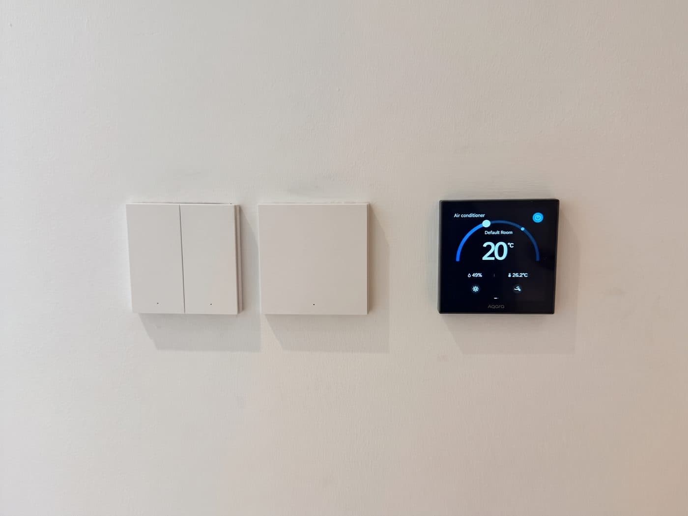 Two Aqara no-neutral smart switches beside an Aqara W400 thermostat running the VRF zone, on a hallway wall in an Al Barari villa